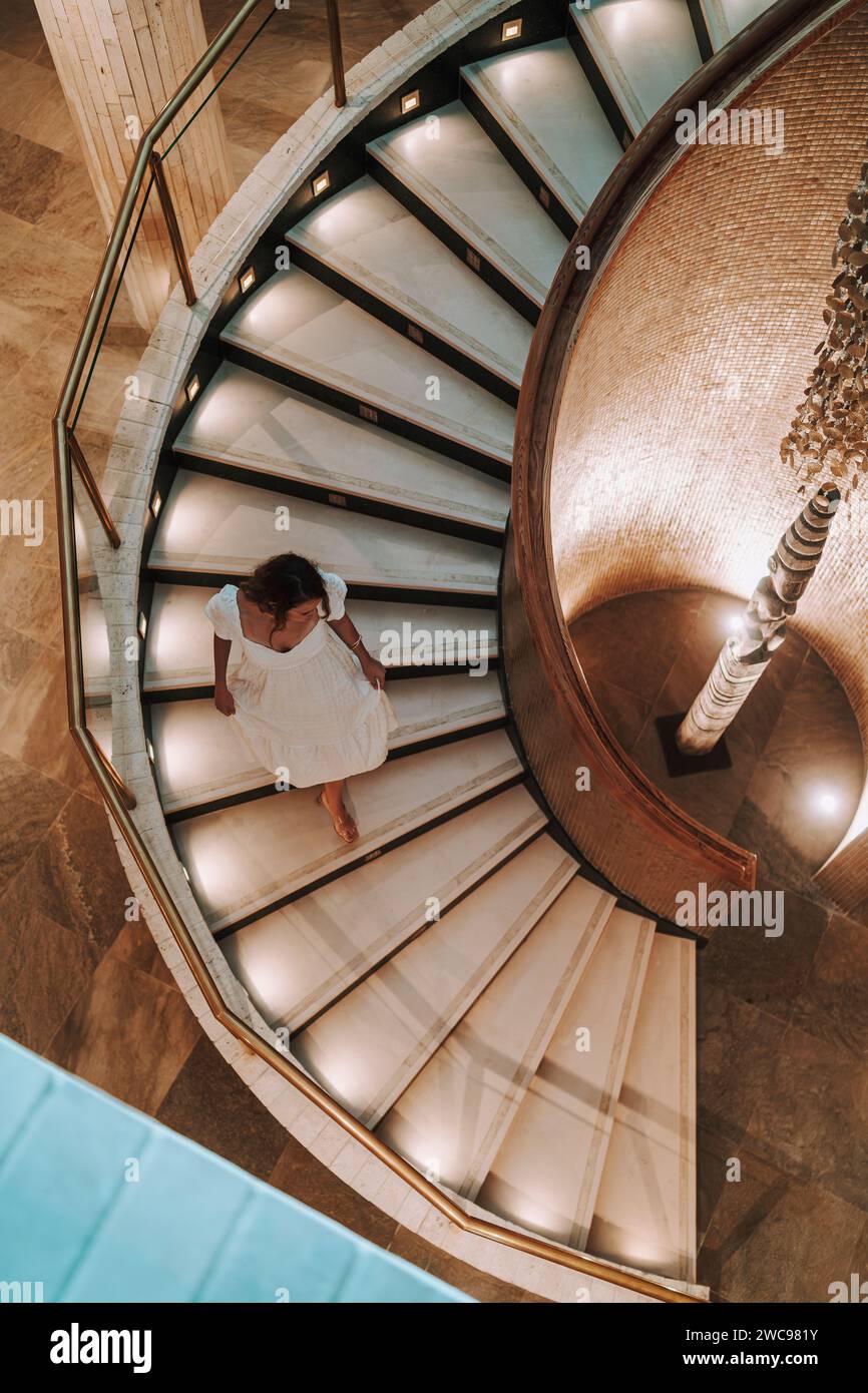 Una donna caucasica che posa alle scale di un hotel Foto Stock