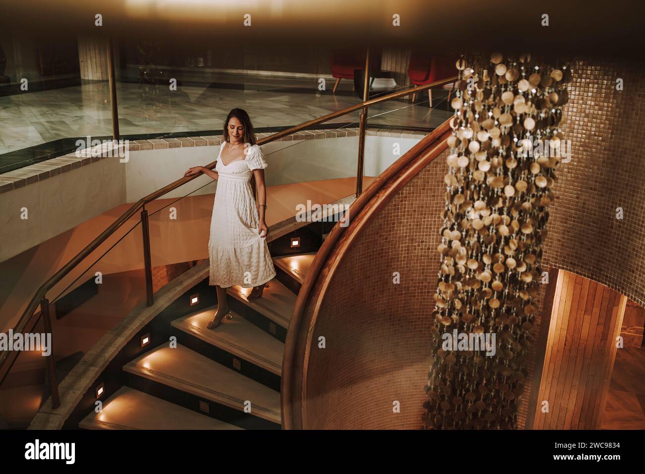 Una donna caucasica che posa alle scale di un hotel Foto Stock