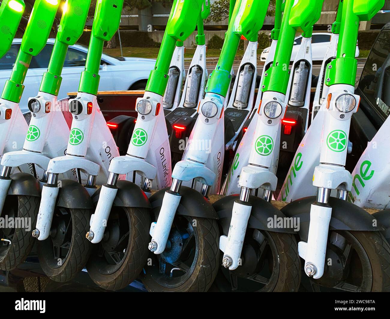 Scooter elettrici calcarei impilati su un carrello Foto Stock