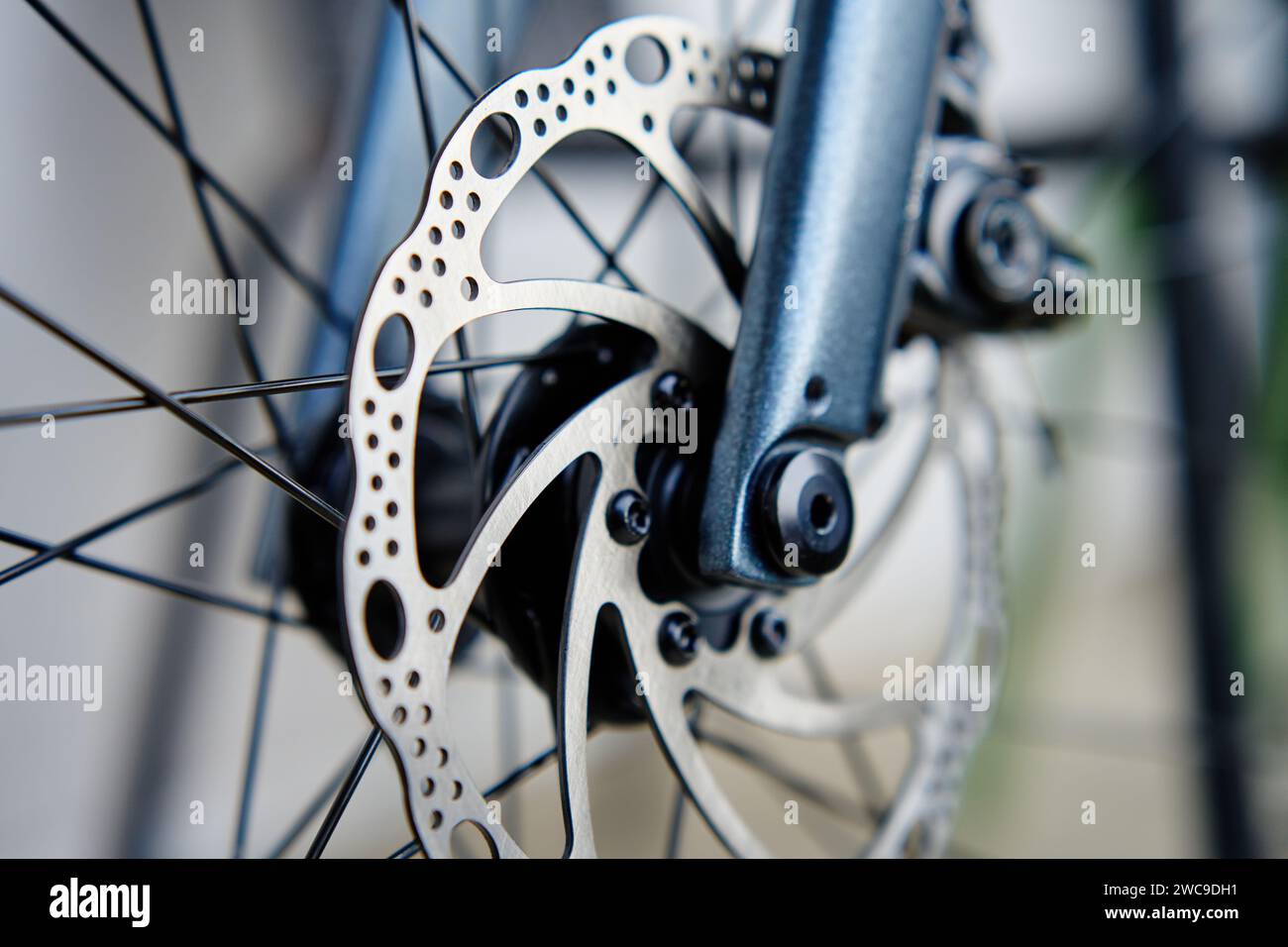 Parte dell'impianto frenante della bicicletta. Disco freno e pastiglie dei freni in metallo grigio sulla bici da strada, primo piano. Foto Stock