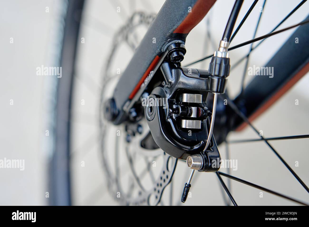 Parte dell'impianto frenante della bicicletta. Disco freno e pastiglie dei freni in metallo grigio sulla bici da strada, primo piano. Foto Stock