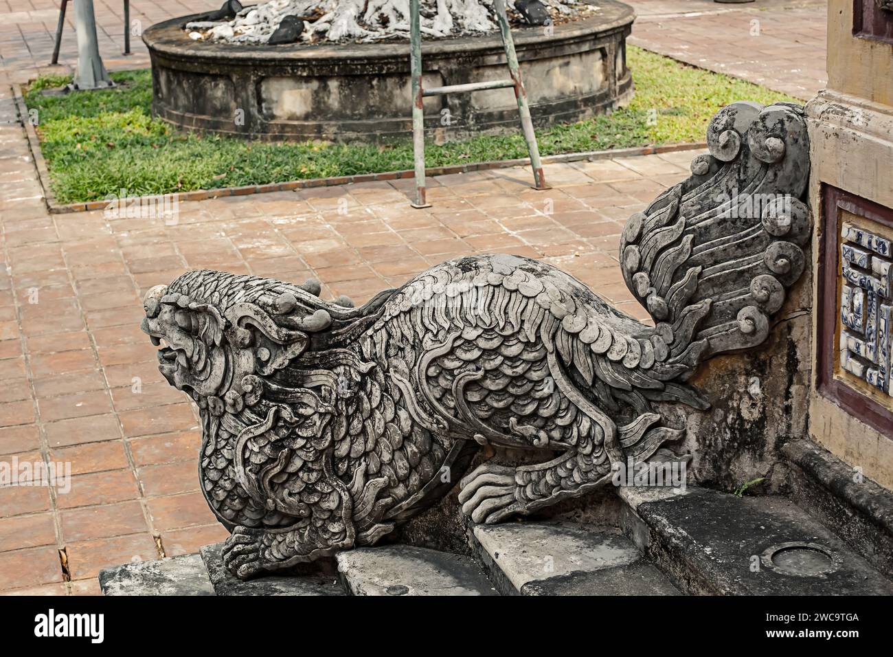 Scultura di drago in pietra intagliata che adorna la scalinata del palazzo storico della città imperiale di Hue, Vietnam Foto Stock