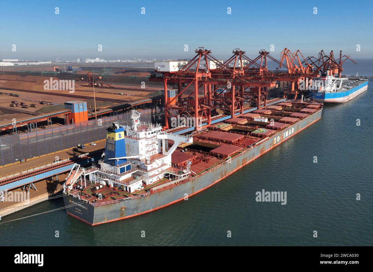 Tangshan. 15 gennaio 2024. Una foto aerea con un drone scattata il 15 gennaio 2024 mostra le navi presso un terminal minerario del porto di Tangshan nella provincia di Hebei nella Cina settentrionale. Nel 2023, secondo le autorità portuali, il trasporto merci al porto di Tangshan ha superato i 842,17 milioni di tonnellate, con un aumento del 9,53% su base annua. Crediti: Yang Shiyao/Xinhua/Alamy Live News Foto Stock