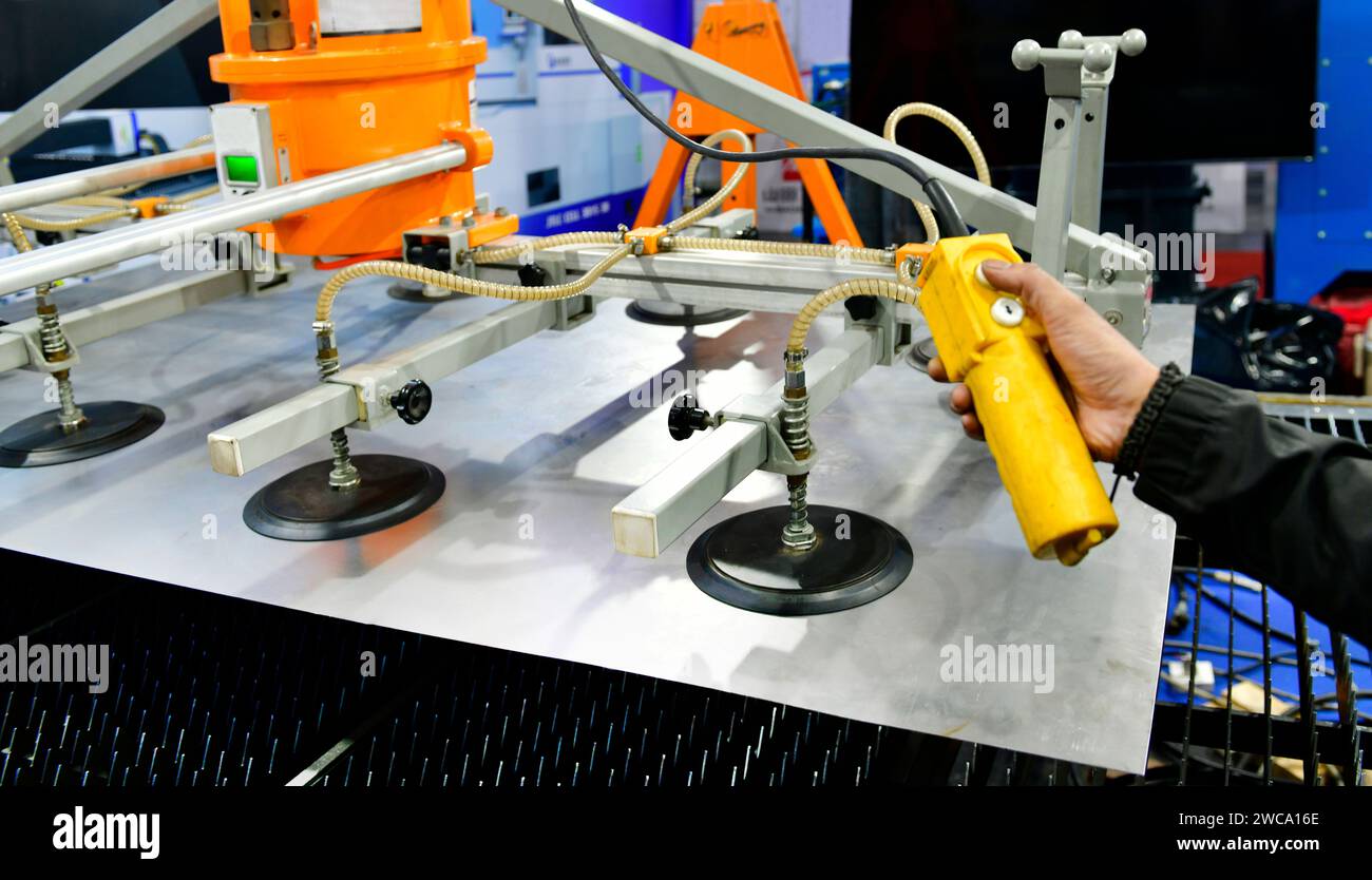Un lavoratore sta premendo un pulsante di controllo del piano d'acciaio per accedere al processo di taglio dell'acciaio nella fabbrica industriale Foto Stock