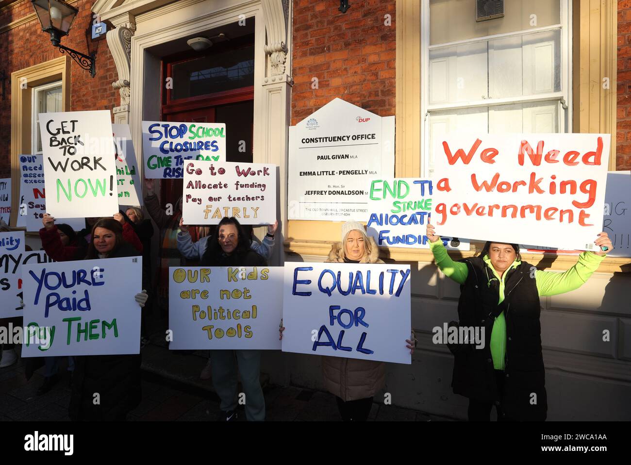 I genitori del Colin Autism Support & Advice Group protestano fuori dall'ufficio elettorale del leader del DUP Sir Jeffrey Donaldson MP a Lisburn. Data immagine: Lunedì 15 gennaio 2024. Foto Stock