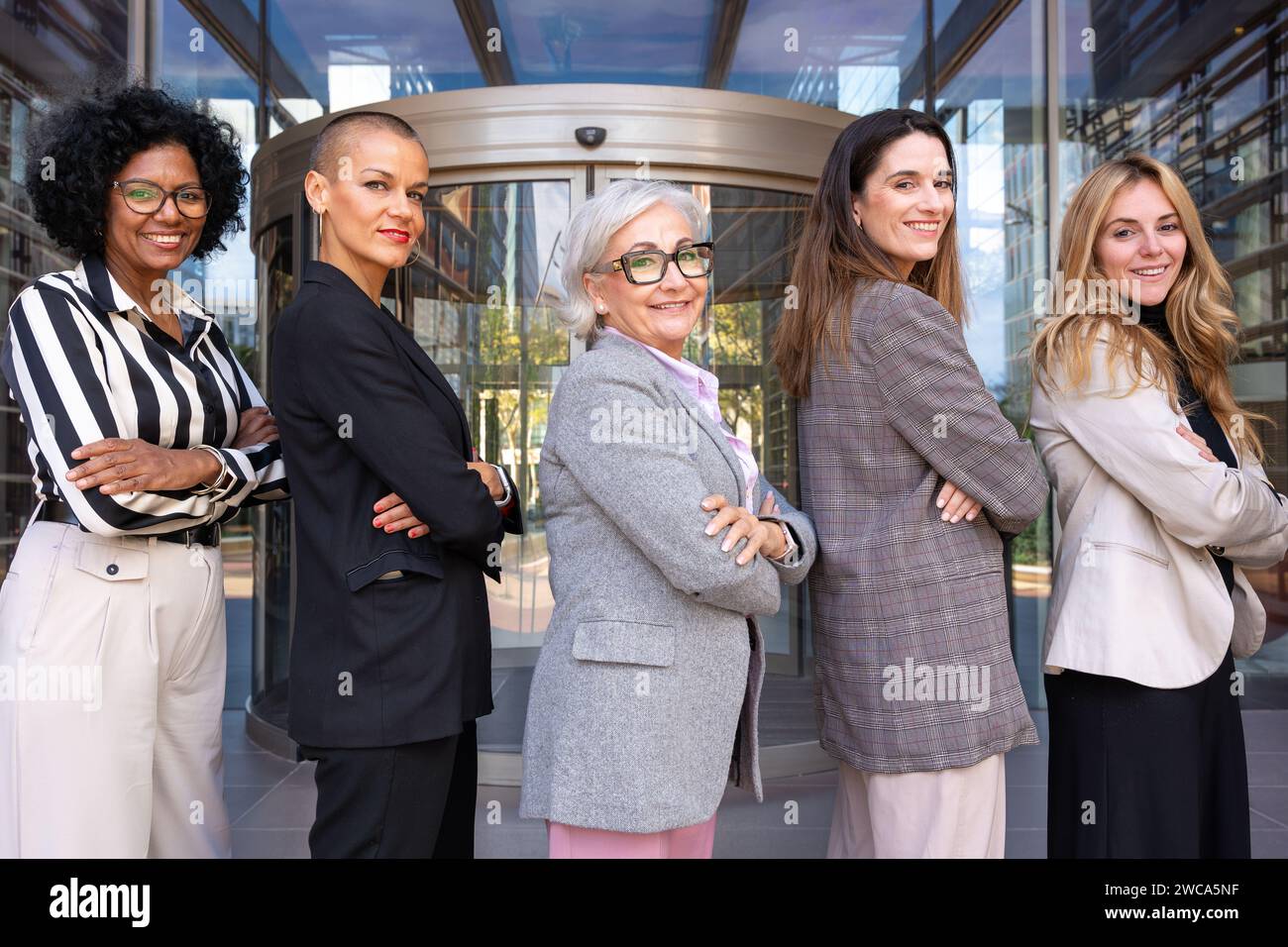 Un team di donne d'affari multirazziali e diverse ha guidato il boss in posa una dopo l'altra per la telecamera. Foto Stock