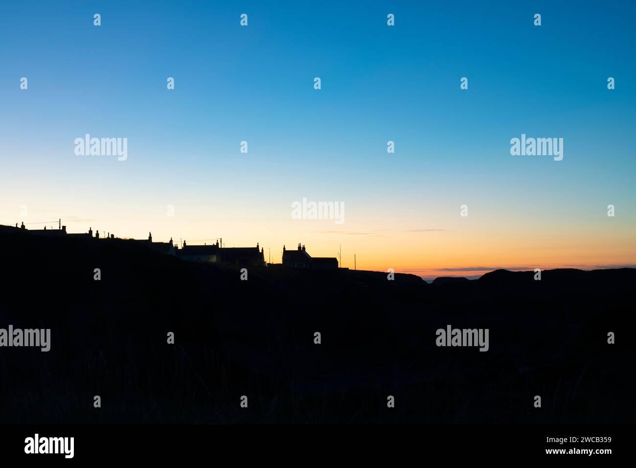 Silhouette ospita i tetti al crepuscolo. Portknockie, Morayshire, Scozia. Foto Stock