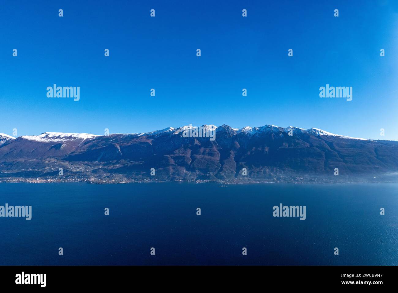 Vista da Tignale sul Lago di Garda del panorama delle cime innevate del Monte Baldo. Foto Stock