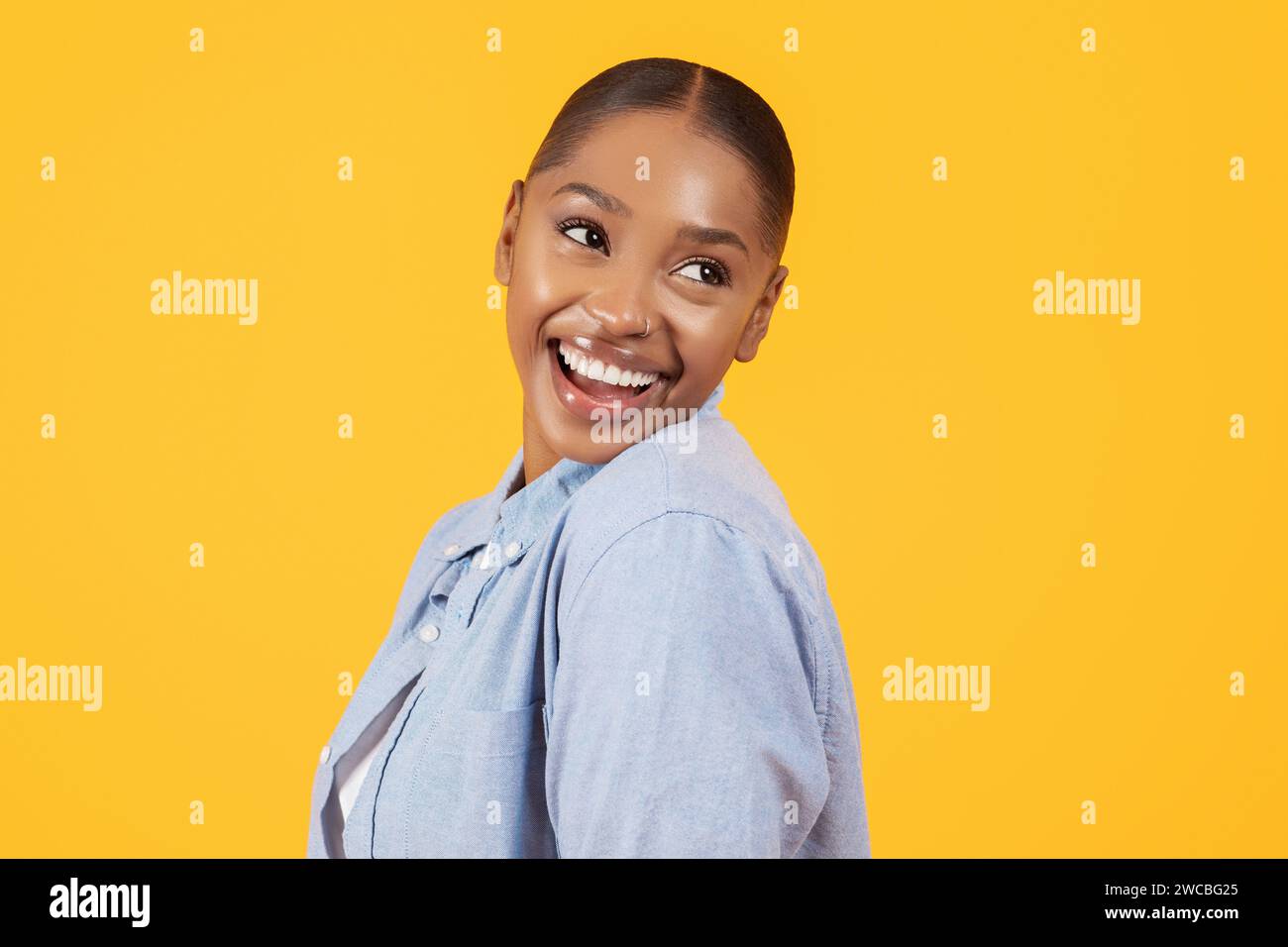 Ritratto di una bella donna nera che sorride a guardare da parte, studio Foto Stock
