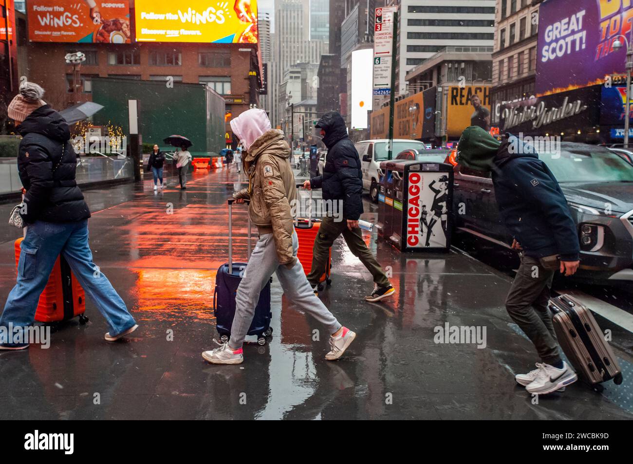 I turisti con le loro valigie rotolano sotto la pioggia e dormono a Times Square a New York domenica 7 gennaio 2024. (© Richard B. Levine) Foto Stock