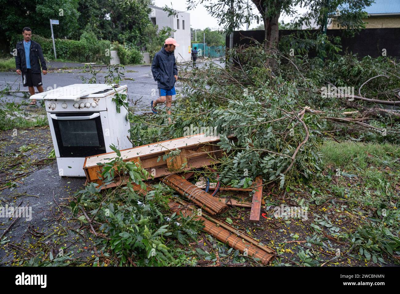 Des habitants constatent les arbres arrachés et débris qui encombrent une Route à Saint-Pierre, quelques heures après le passage du cyclone Belal, le Foto Stock