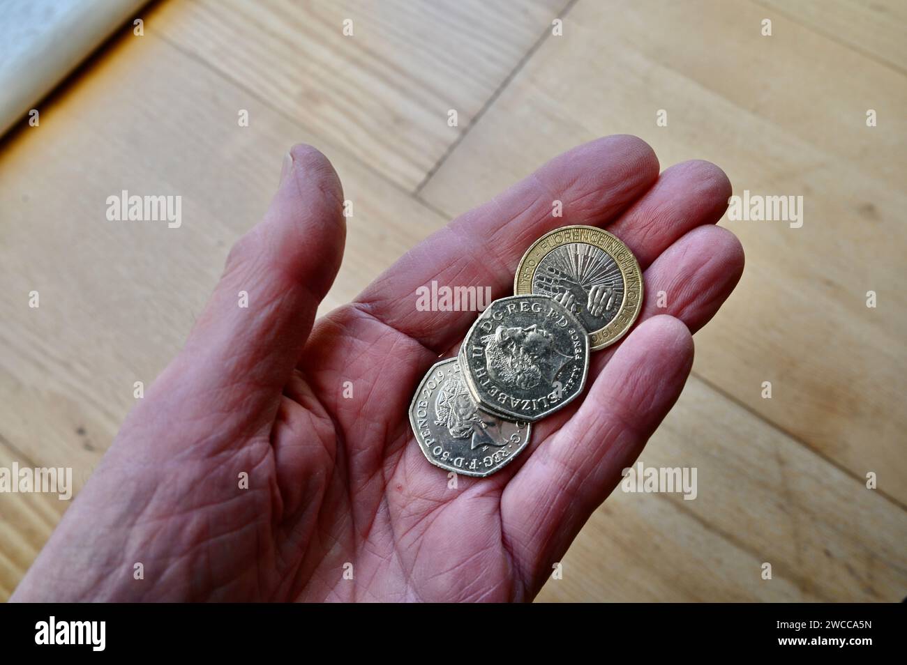 Cinquanta penny e due sterline in circolazione. Foto Stock