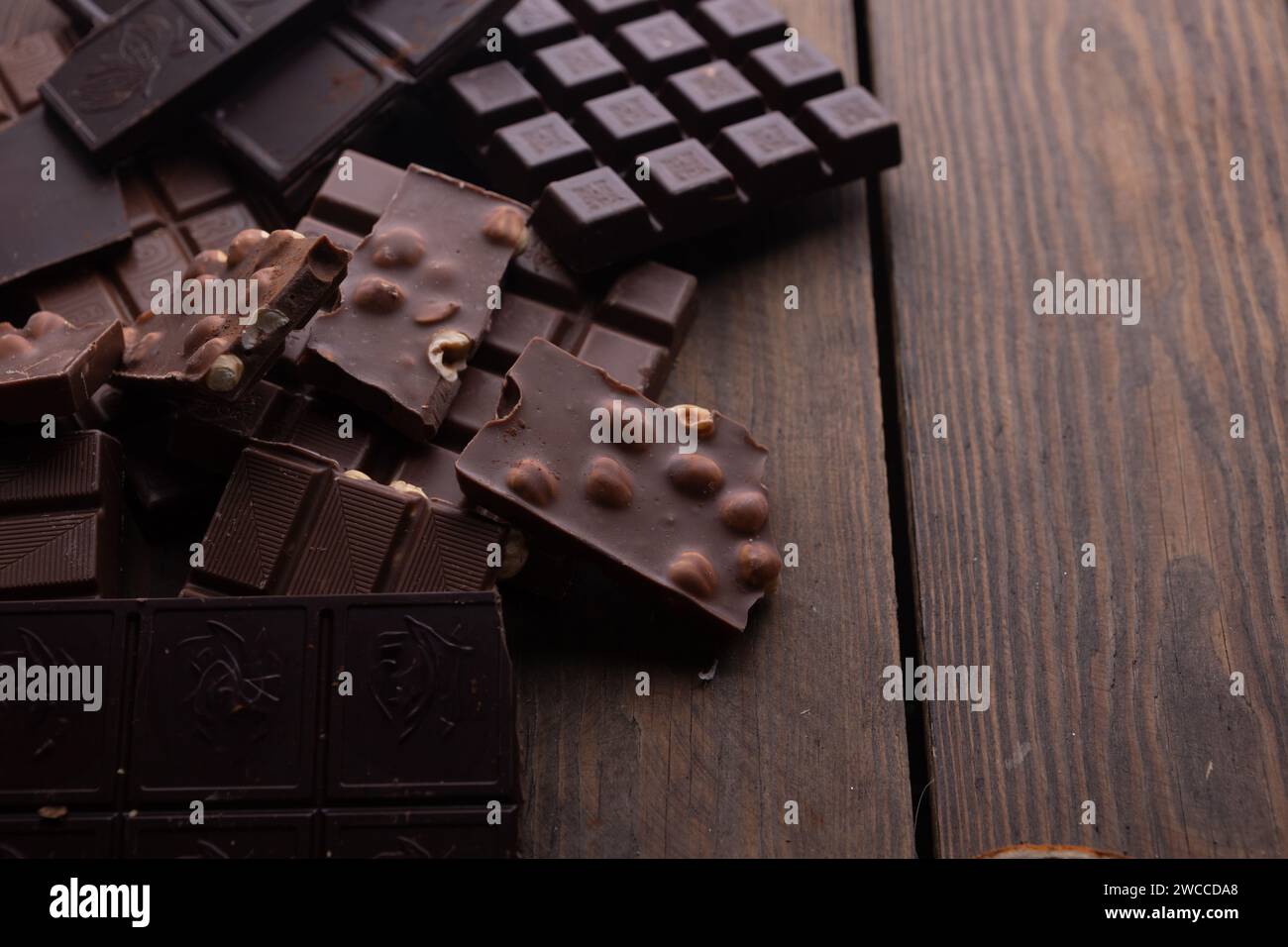 Cioccolato schiacciato su uno sfondo rustico. Diversi tipi di cioccolato Foto Stock