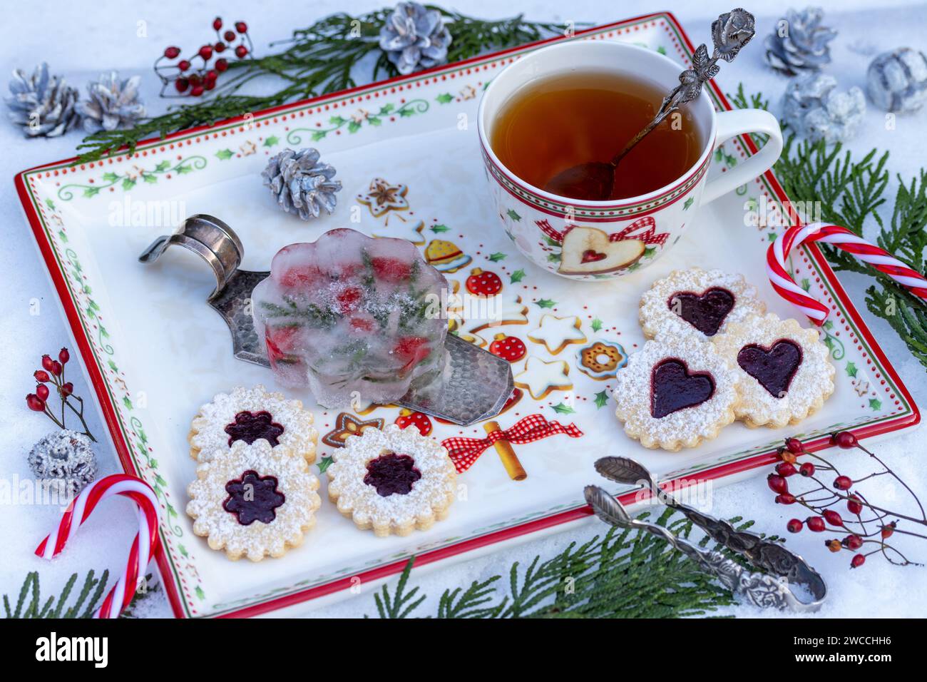 Decorazione natalizia con figura di ghiaccio, biscotti Spitzbuben e tazza di tè Foto Stock