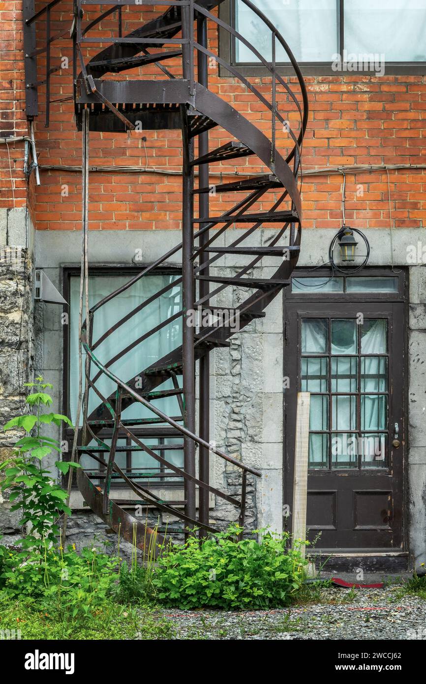 Scale a spirale arrugginite metalliche all'esterno su un edificio in mattoni a Montreal, Canada Foto Stock