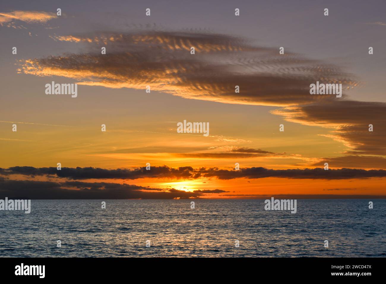 Cielo al tramonto sul mare, panorama con cielo colorato di nuvole sul mare blu Foto Stock
