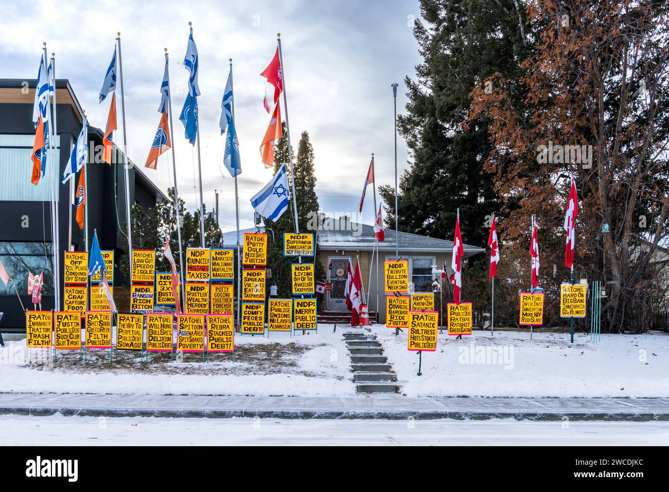Edmonton, Canada, 10 dicembre 2023: Casa di fronte al cortile della città di Edmonto con poster dell'agenda politica e bandiere multiple sul cielo scuro Foto Stock