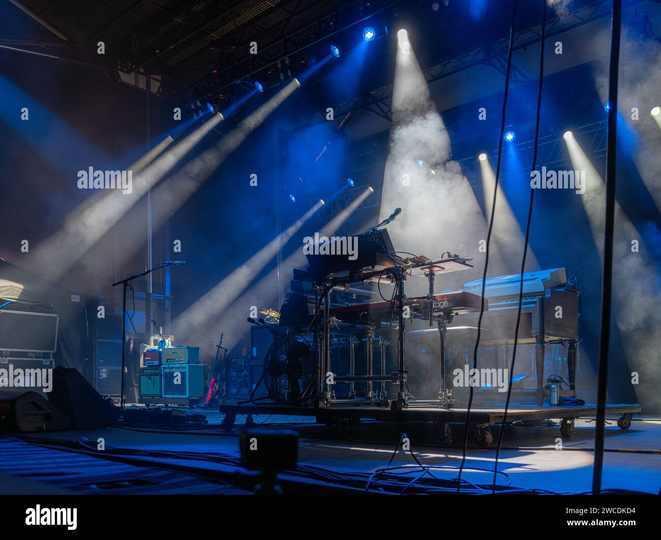 Un palco da concerto con una configurazione della tastiera avvolto da un'incredibile illuminazione blu e foschia Foto Stock