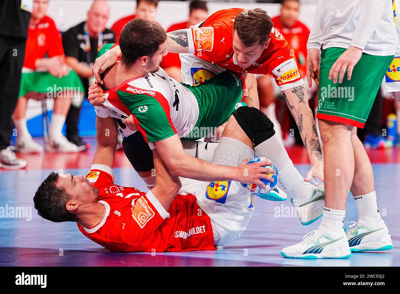 Denmarks Rasmus Lauge, Bottom, ed Emil Jakobsen, top, durante la gara di mens EHF Euro 2024 tra Danimarca e Portogallo all'Olympiahalle di Monaco, Germania, lunedì 15 gennaio 2024 Foto Stock