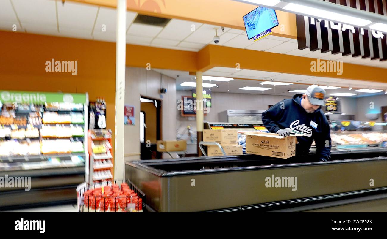 Lavoratore in un negozio di alimentari Kroger che vende gamberi di grandi dimensioni in un'unità refrigerata - novembre 2023 Foto Stock