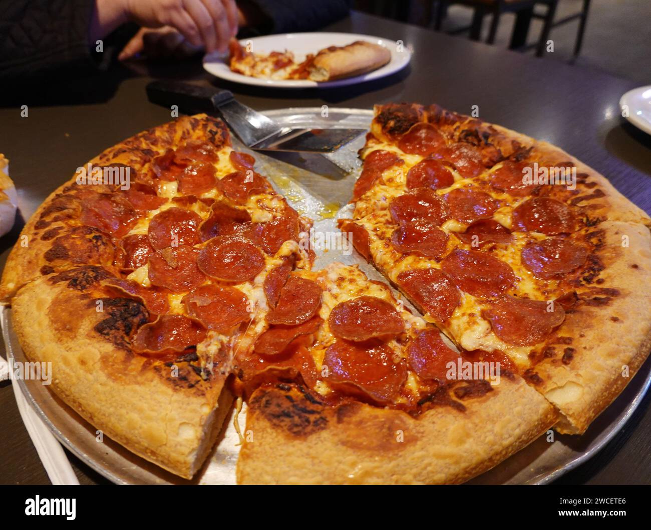 Primo piano di una pizza troppo cotta al Pizza Hut - novembre 2023 Foto Stock