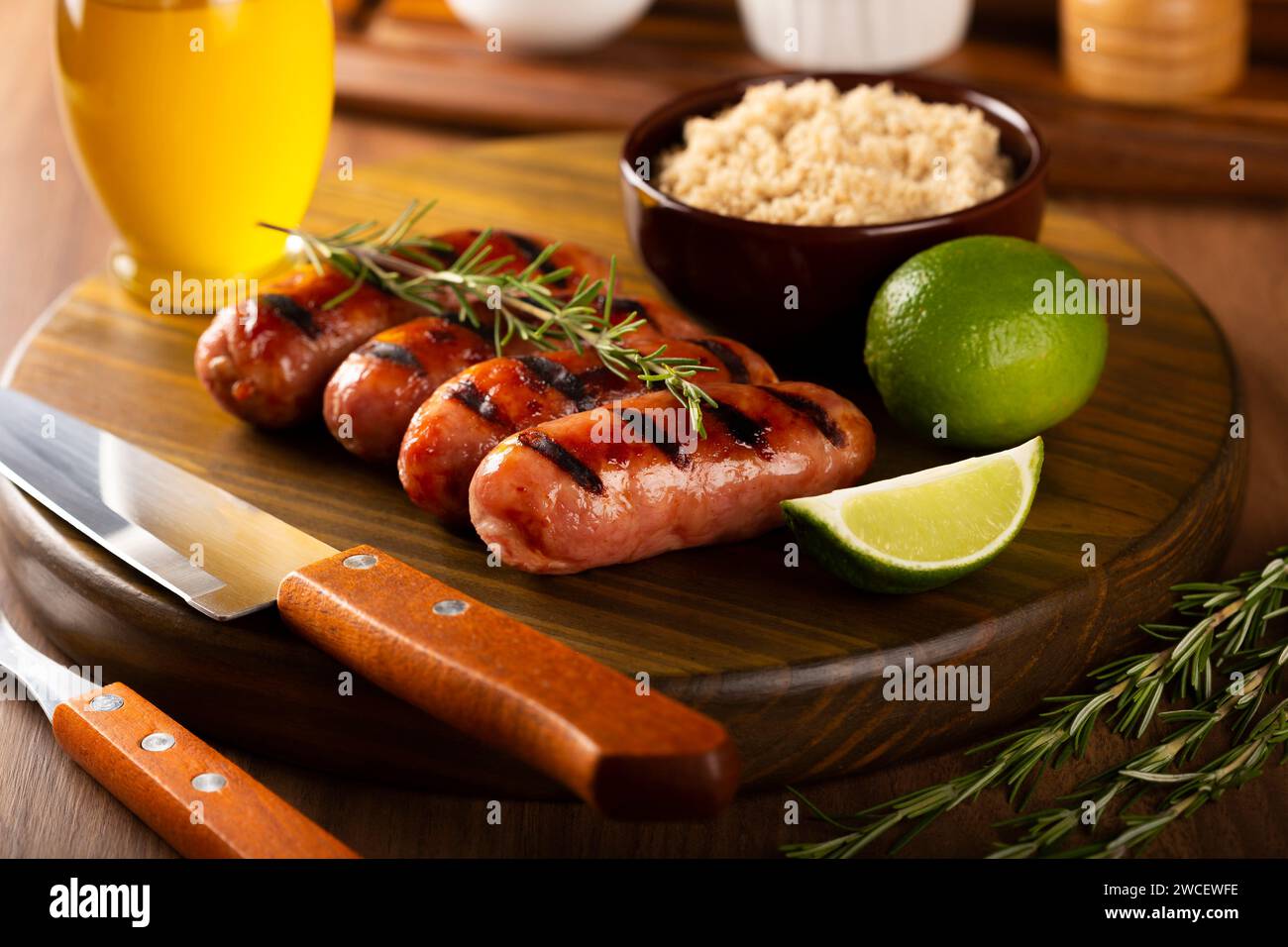 Salsicce grigliate con barbecue su sfondo di legno. Foto Stock