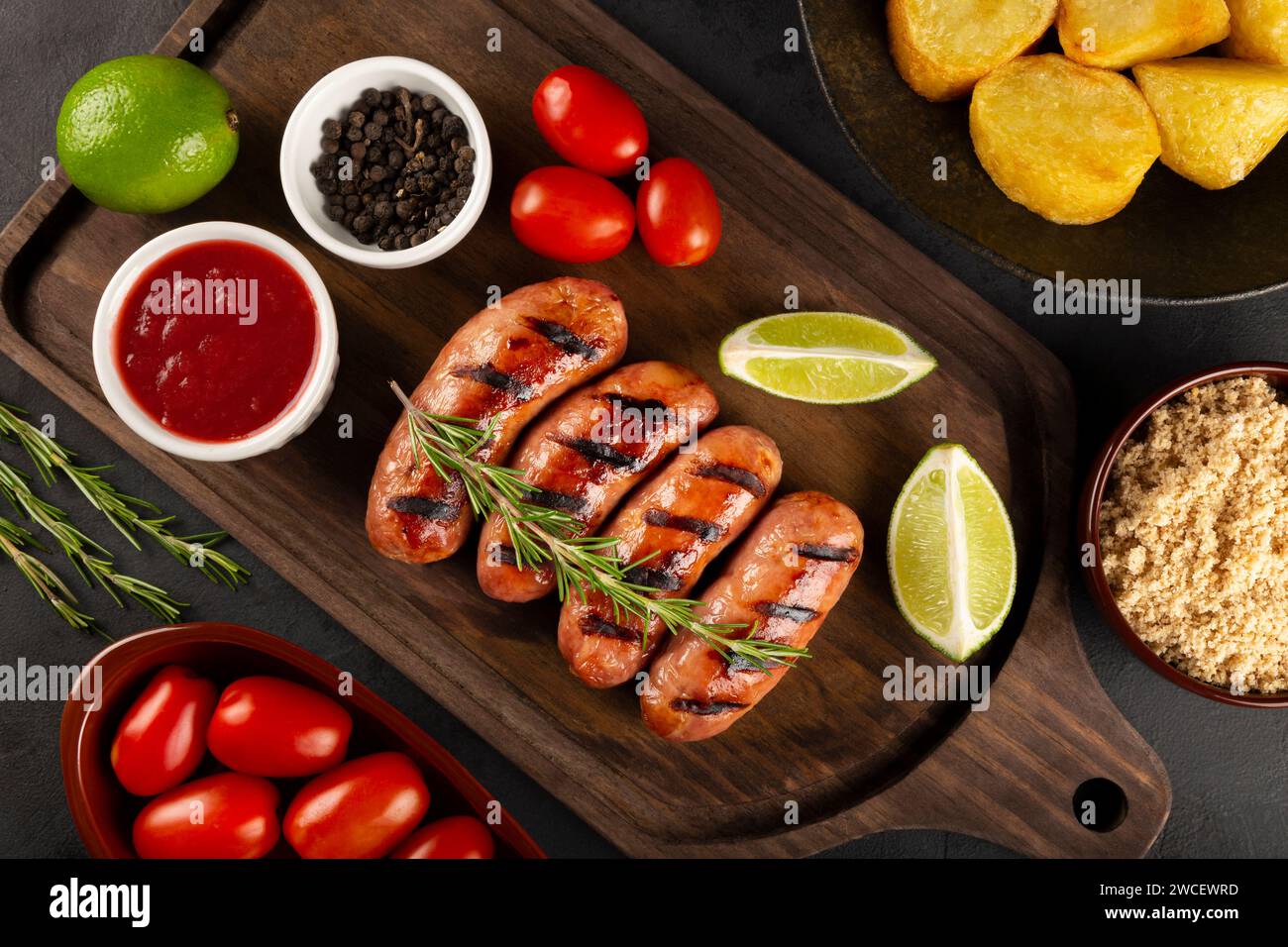 Salsicce grigliate con barbecue su sfondo di legno. Foto Stock