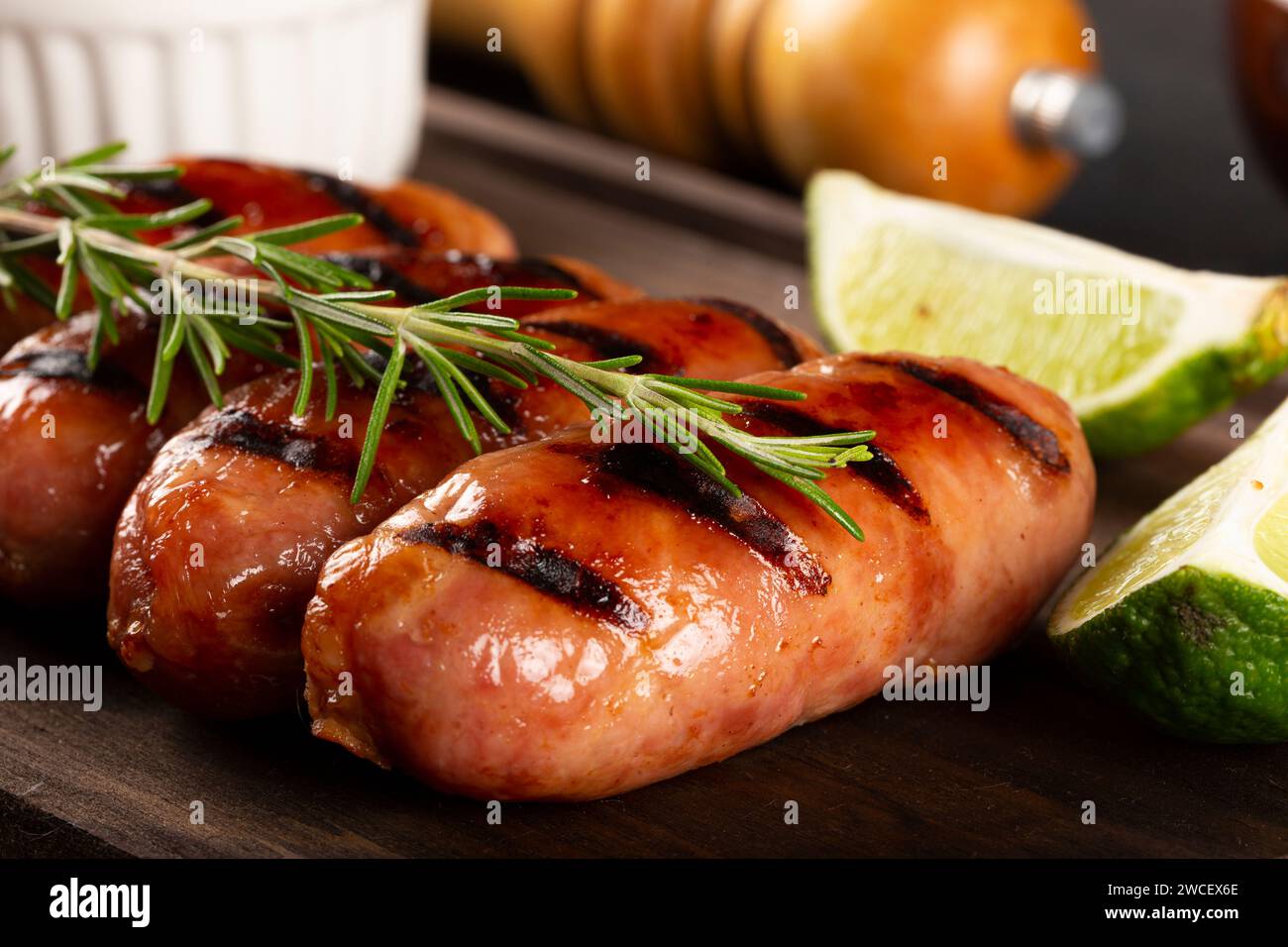 Salsicce grigliate con barbecue su sfondo di legno. Foto Stock
