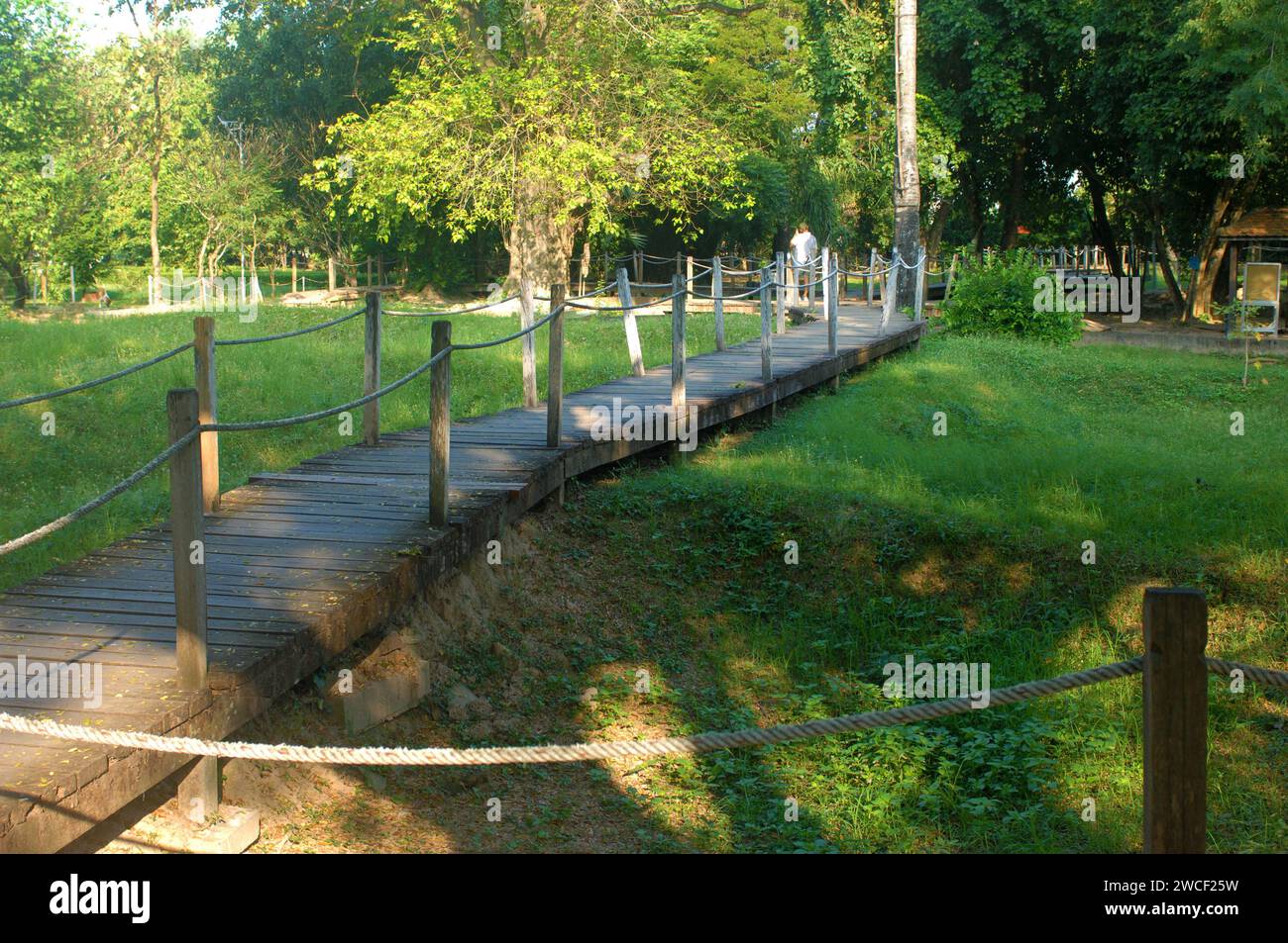 Sentiero in legno attraverso i campi di sterminio del Choung EK genocidal Center, Phnom Penh, Cambogia. Foto Stock