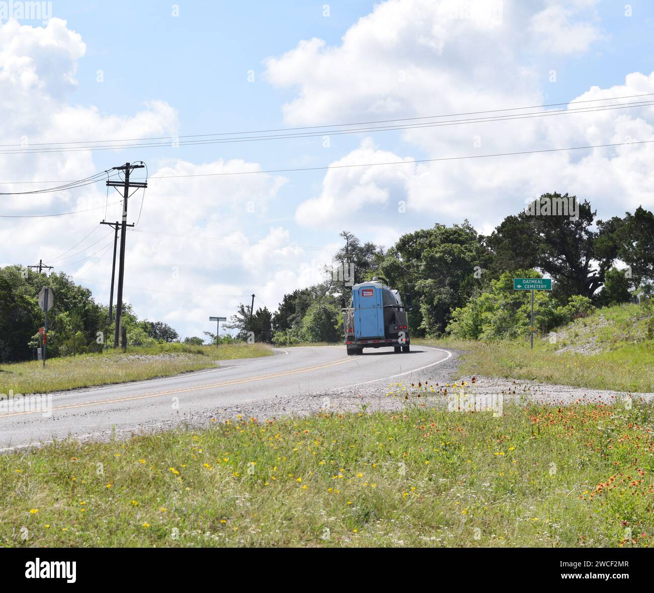 Honey Bucket servizi igienici portatili trasportati su un camion che guida su un'autostrada attraverso la farina d'avena in Texas - maggio 2023 Foto Stock