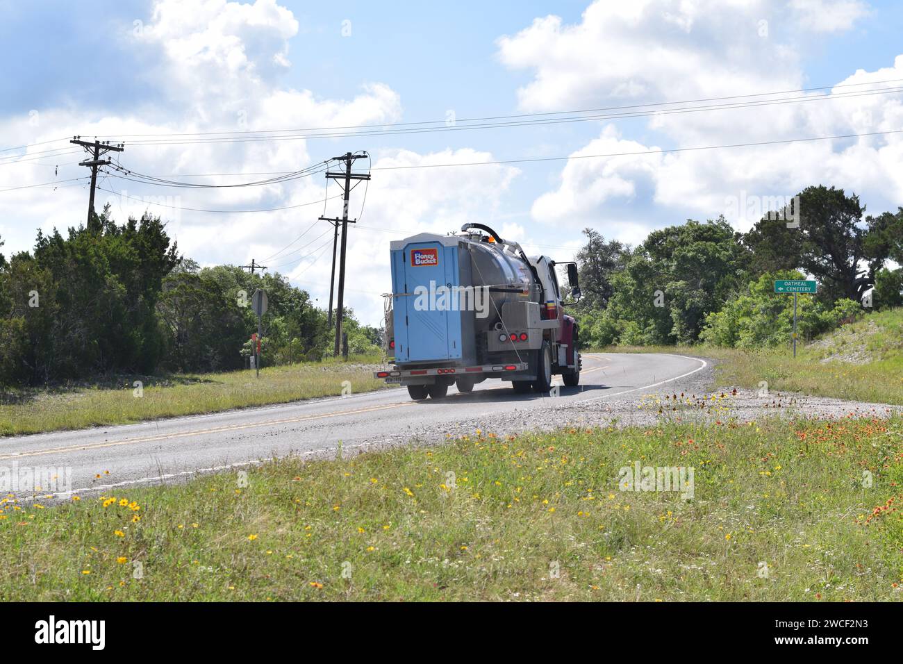 Honey Bucket servizi igienici portatili trasportati su un camion che guida su un'autostrada attraverso la farina d'avena in Texas - maggio 2023 Foto Stock