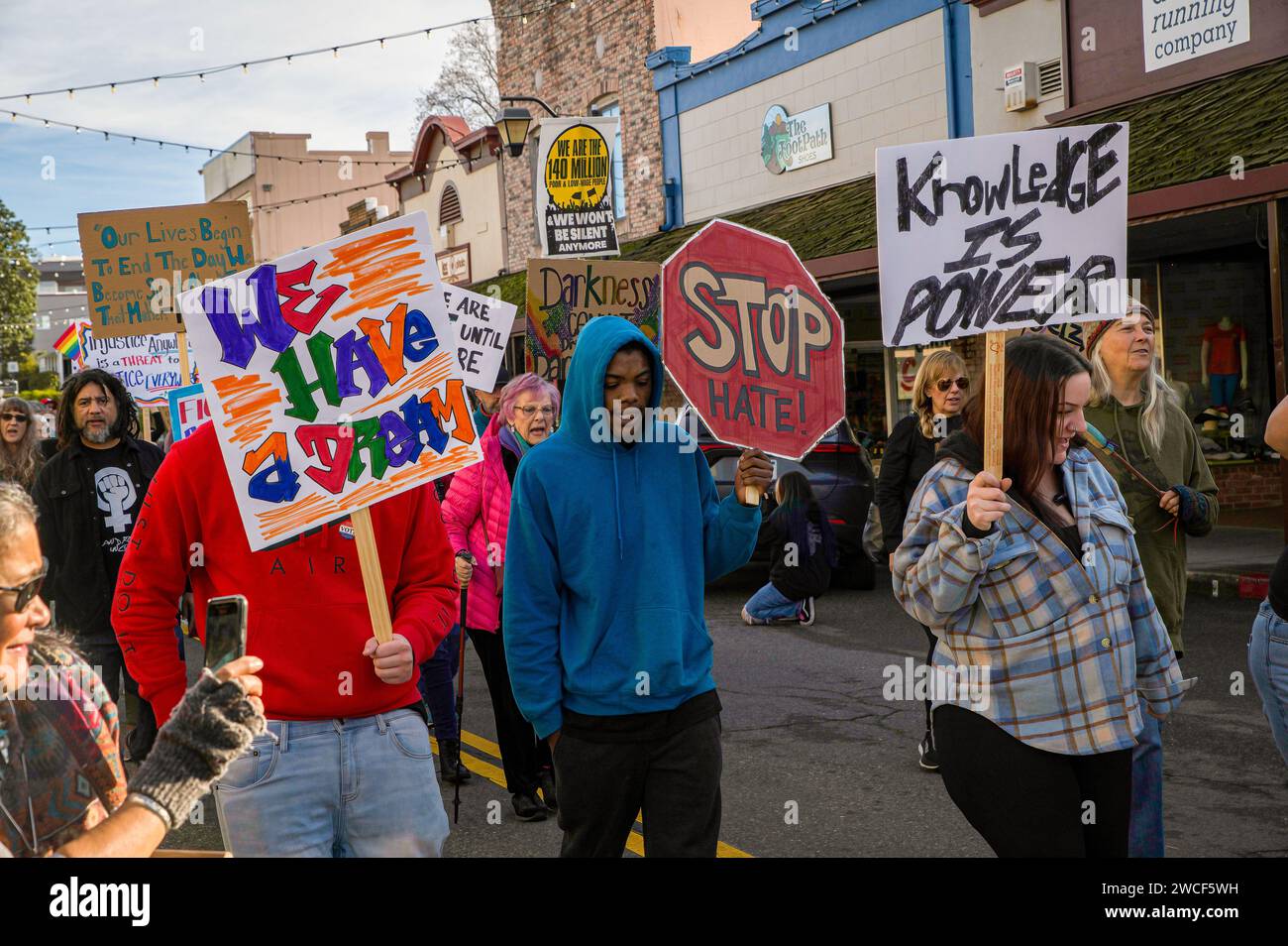 I marciatori con indicazioni su come fermare l'odio e fare un sogno in centro città come parte di un evento di vacanza Dr. Martin Luther King Jr. Foto Stock