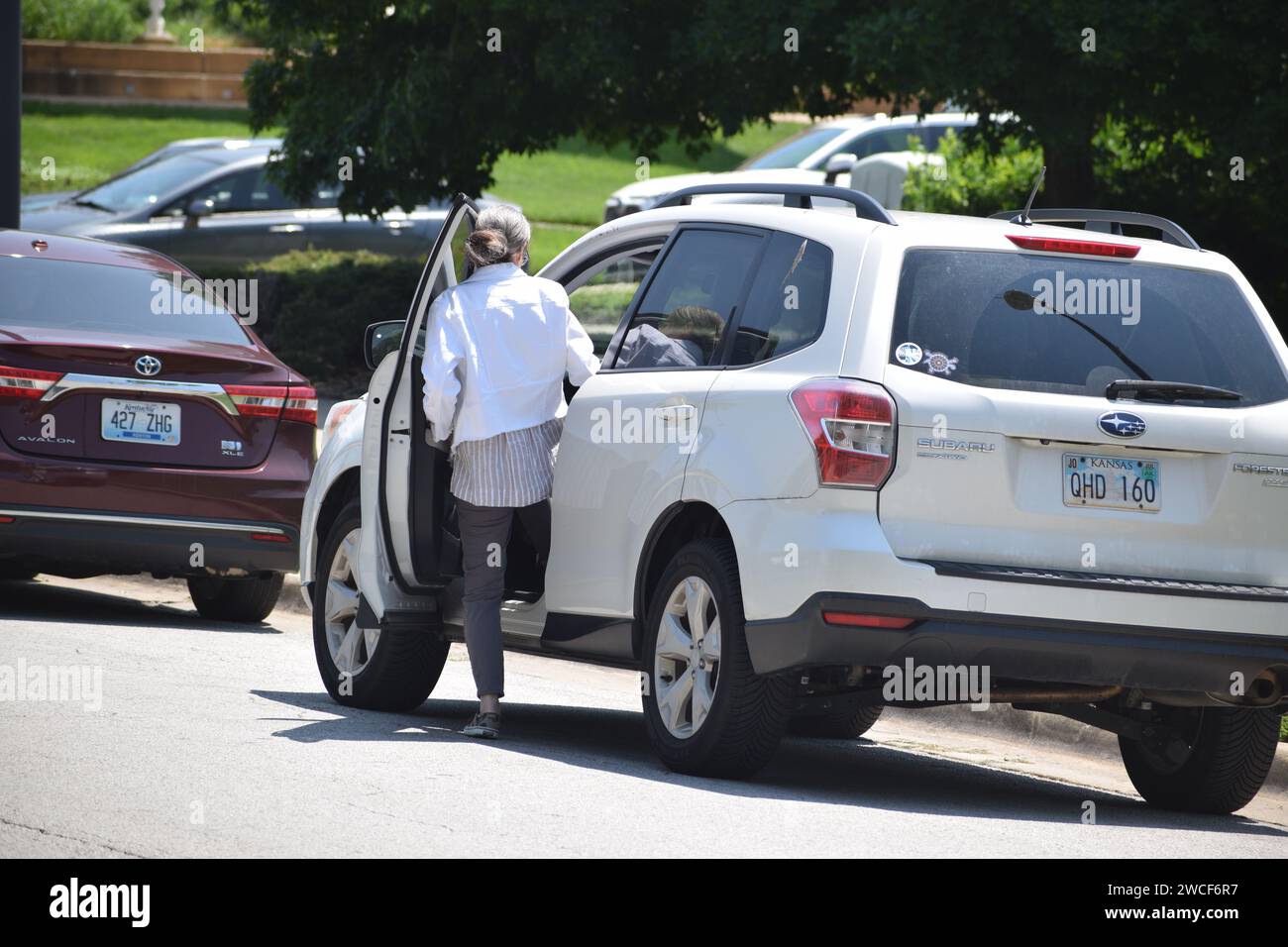 Donna anziana che entra nel suo bianco Subaru Forester - maggio 2023 Foto Stock