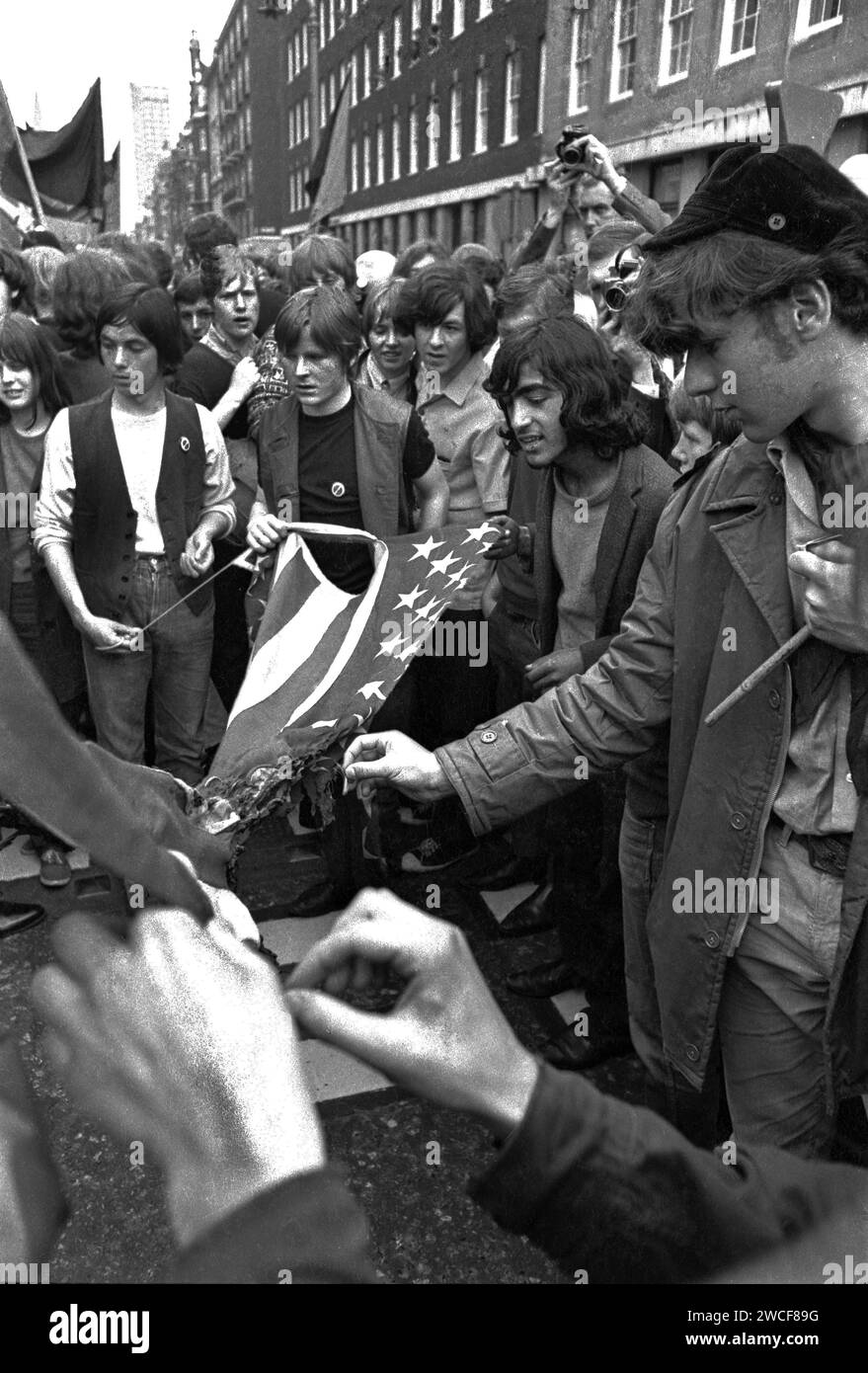 Manifestanti in Grosvenor Street a Londra che tentano di bruciare una bandiera americana vicino all'ambasciata degli Stati Uniti in Grosvenor Square durante la marcia di protesta anti-Vietnam del 17 marzo 1968 . A causa del violento scontro tra manifestanti e polizia, questa massiccia protesta divenne nota come "la battaglia di Grosvenor Square" e fu l'ispirazione per la canzone dei Rolling Stones, "Street Fighting Man". Foto Stock