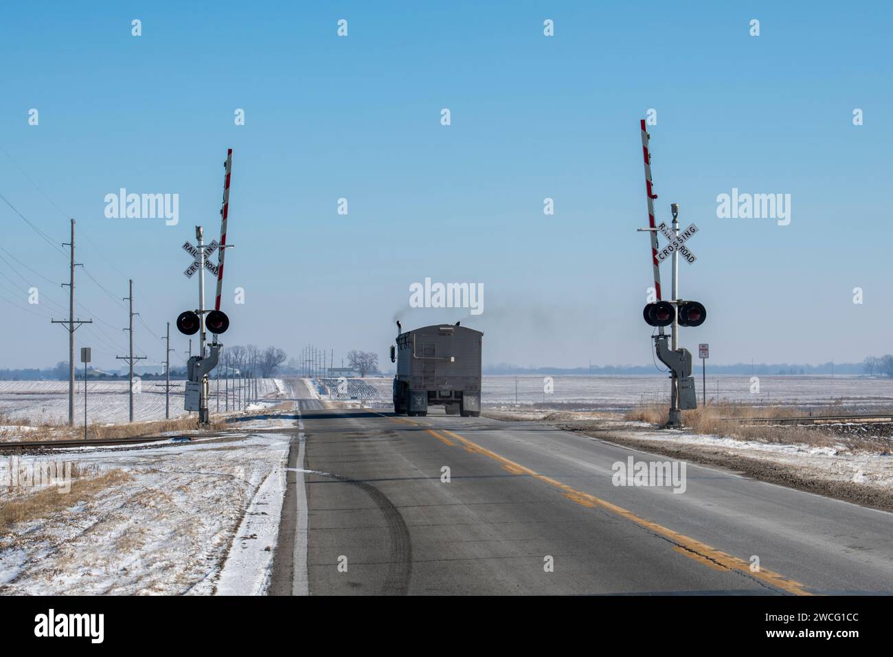 Jewell, Iowa. Camion di grano che attraversa i binari della ferrovia in un paesaggio innevato in inverno. Foto Stock
