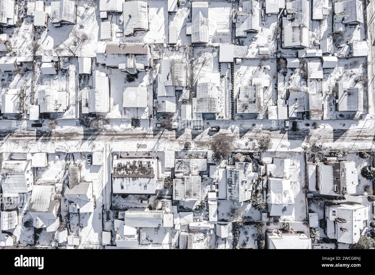 tetti innevati nella zona residenziale dei sobborghi. vista aerea dall'alto dal drone volante. Foto Stock