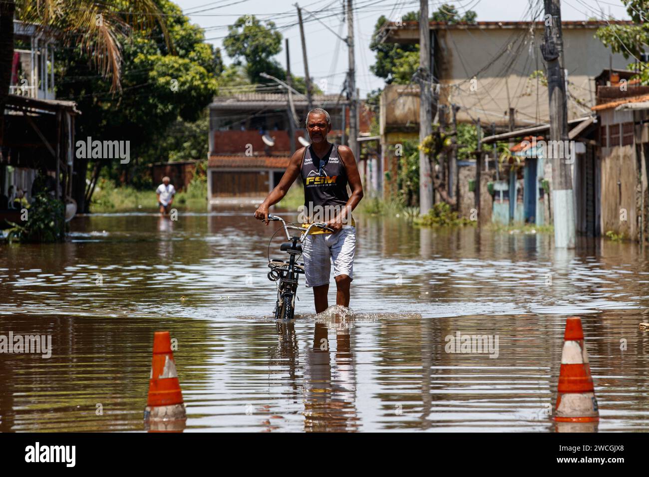 Rio De Janeiro, Brasile. 15 gennaio 2024. Un residente cammina attraverso una strada allagata a Lote XV, Belford Roxo, Rio de Janeiro, Brasile, 15 gennaio, 2024. il bilancio delle vittime della tempesta che ha colpito lo stato sud-orientale brasiliano di Rio de Janeiro domenica è salito a 12, con altre due persone denunciate dispersi, il governatore Claudio Castro ha annunciato lunedì. Crediti: Claudia Martini/Xinhua/Alamy Live News Foto Stock