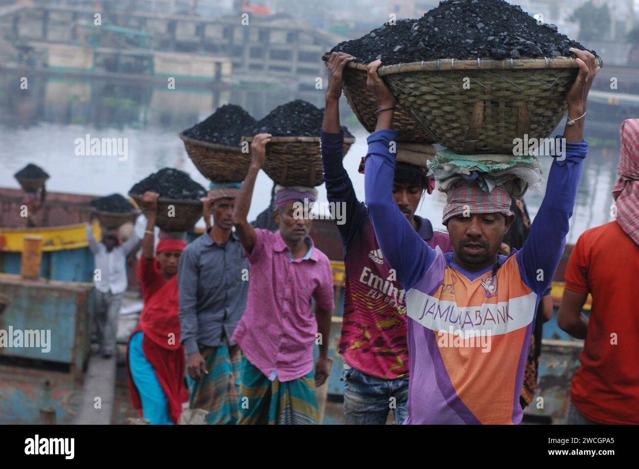 Dhaka, Bangladesh. 16 gennaio 2024. I lavoratori scaricano carbone da una nave da carico in un mercato all'ingrosso di carbone a Dacca. (Immagine di credito: © MD Mehedi Hasan/ZUMA Press Wire) SOLO USO EDITORIALE! Non per USO commerciale! Foto Stock