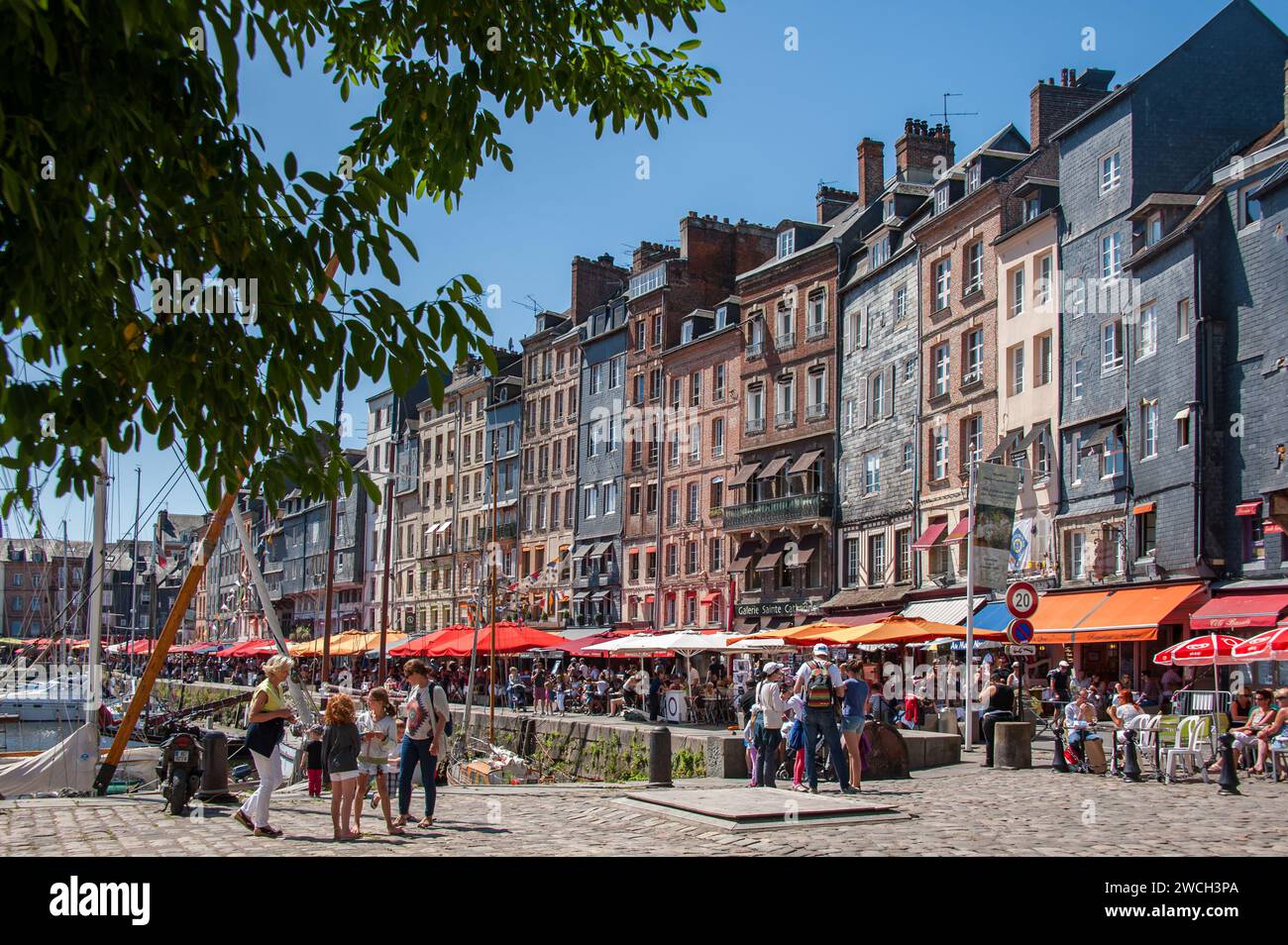 Honfleur, Francia - 9 agosto 2016: Case e ristoranti nel vecchio porto di Honfleur in una giornata di sole in estate, cielo blu Foto Stock