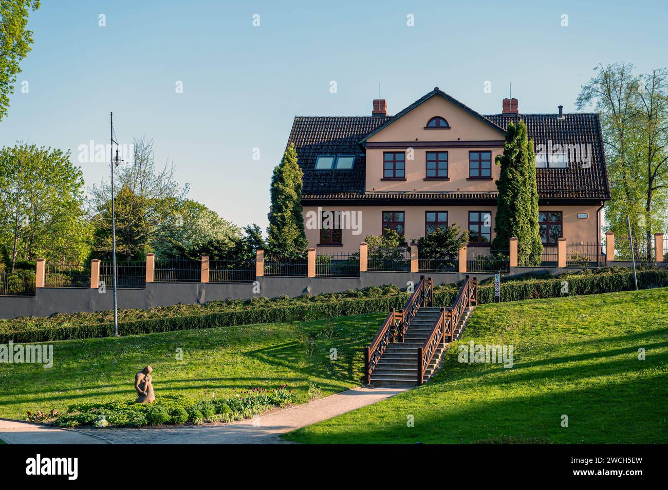 Parco della città vecchia di Kuldiga con sentieri per passeggiate ed edifici adiacenti, Lettonia Foto Stock