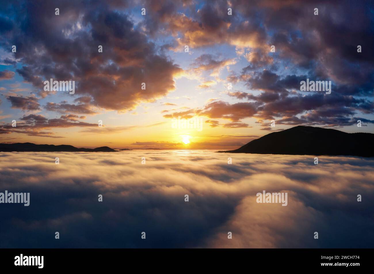 Bella alba sulle montagne. Paesaggio panoramico con un suggestivo cielo sopra fitte nuvole nella valle di montagna. Vista aerea con droni. Foto Stock