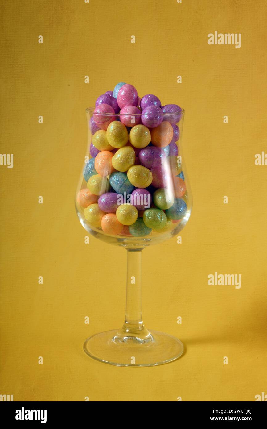 Foto verticale con vetro centrato con uova di Pasqua color pastello. Foto Stock