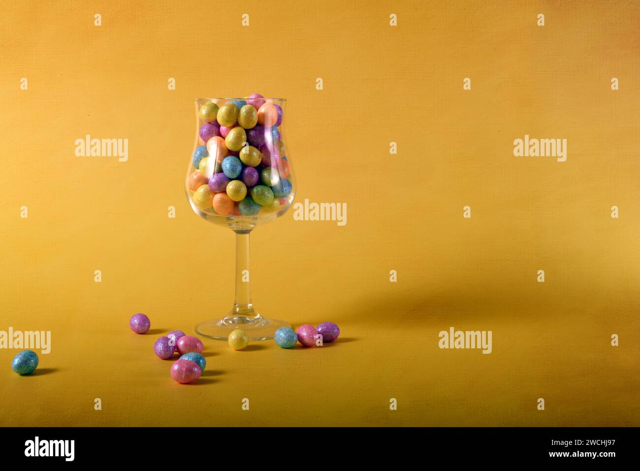 Foto orizzontale di vetro con piccole uova di Pasqua colorate. Copia spazio a destra. Foto Stock