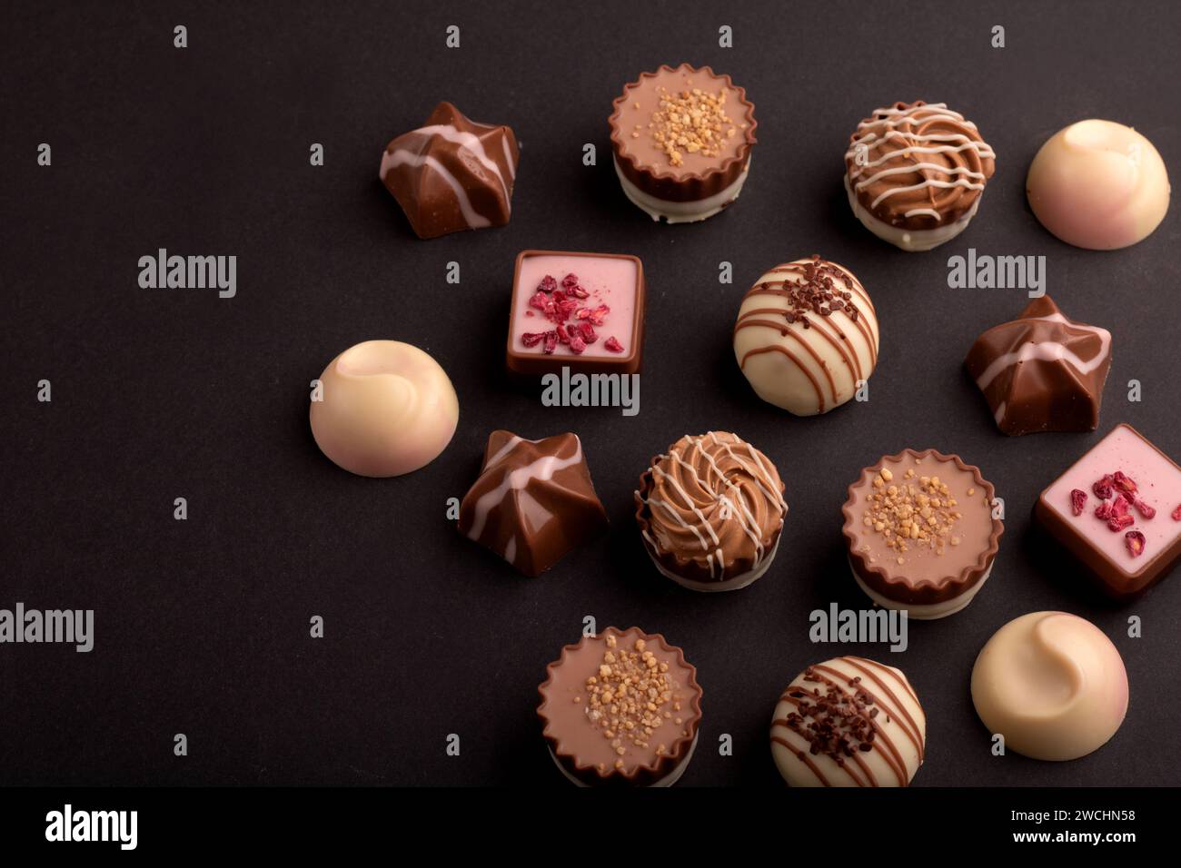 Una foto allettante di un assortimento di tartufi al cioccolato. Questa deliziosa selezione di caramelle e dessert, sullo sfondo, promette un delizioso e dolce piacere Foto Stock