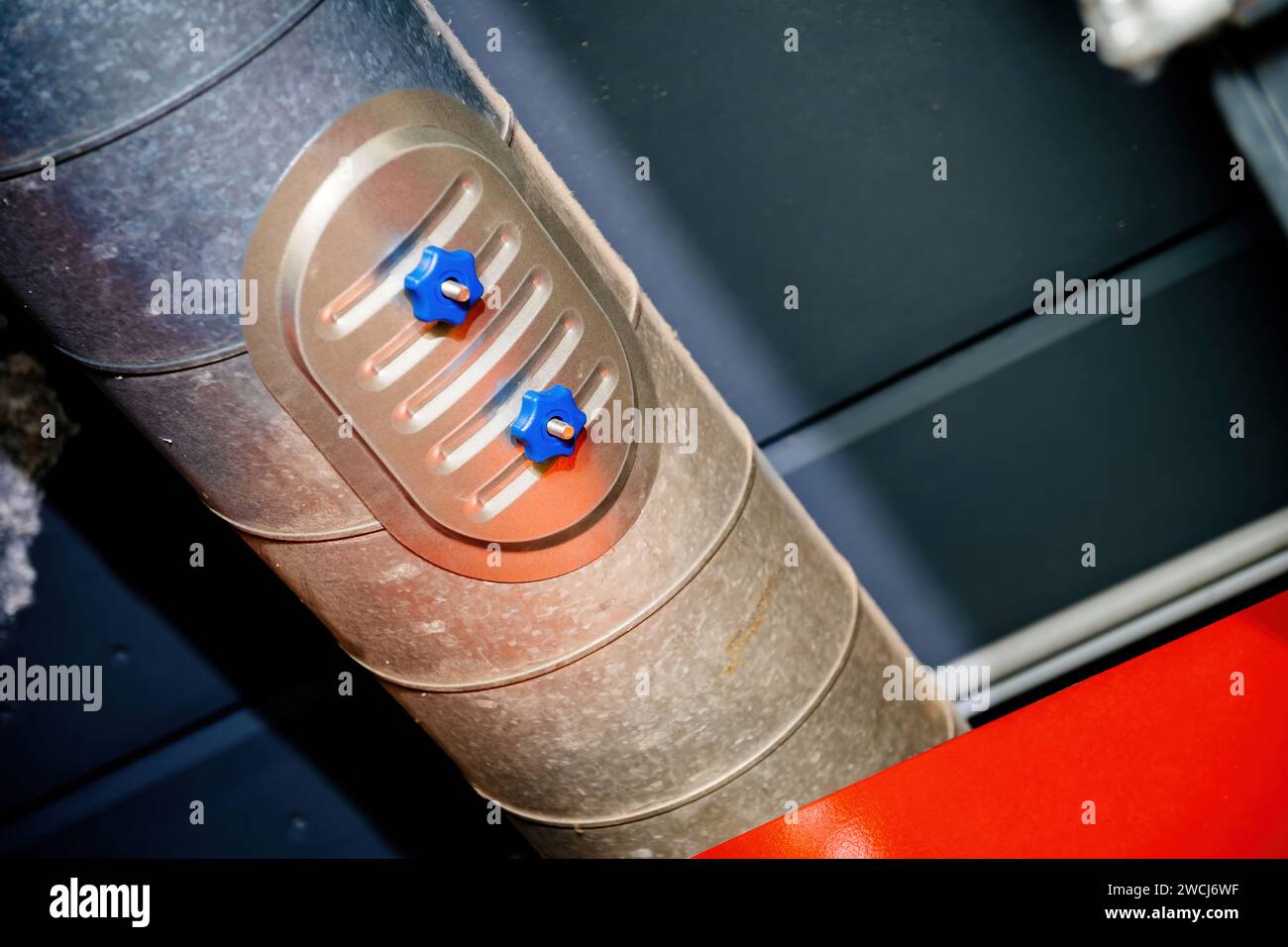 primo piano dettagliato di due controlli delle valvole industriali blu incorporati in una superficie metallica, che mostrano i moderni componenti meccanici. Foto Stock