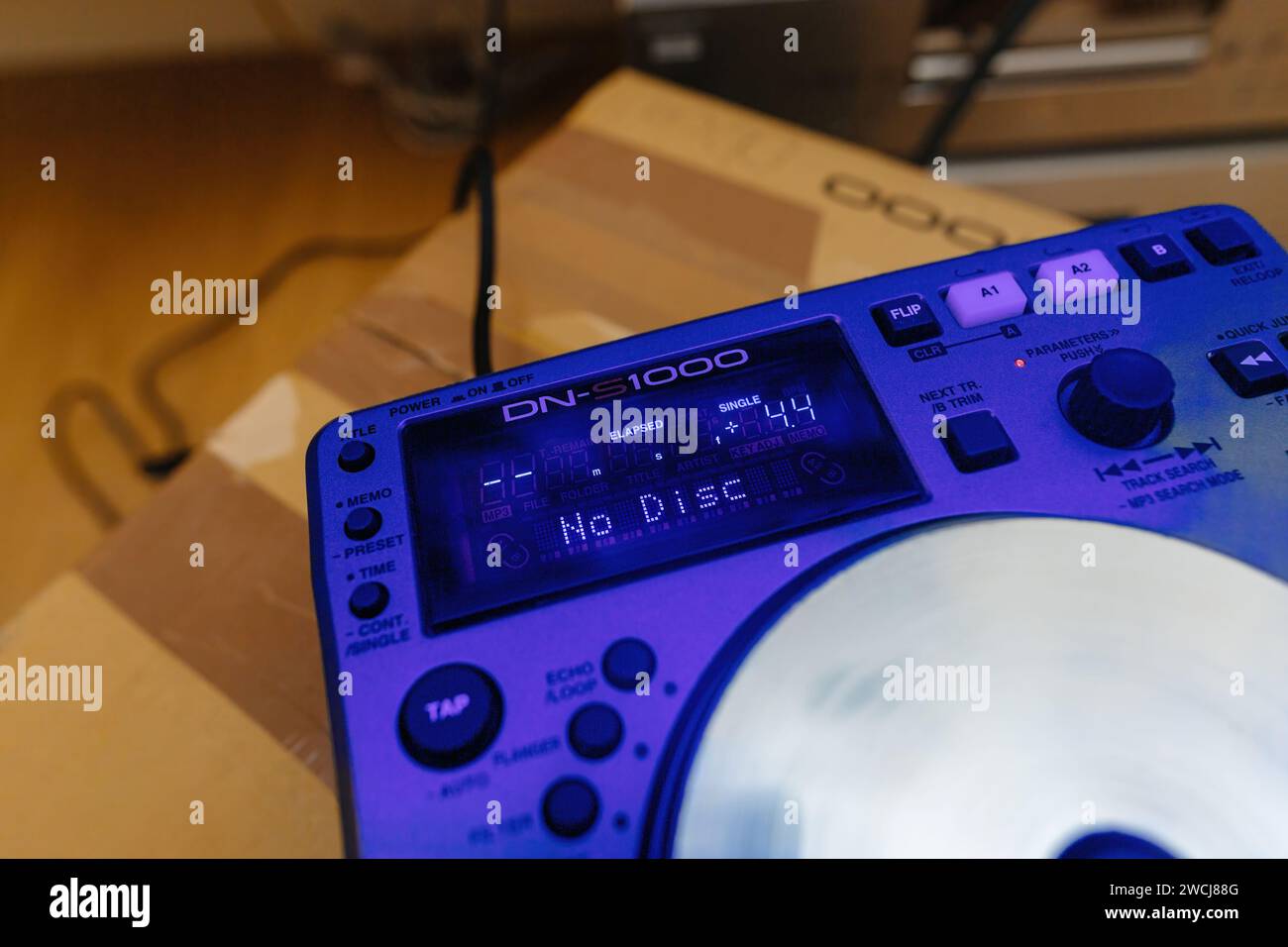 Parigi, Francia - 24 ottobre 2023: Una visione ravvicinata dell'unboxing della nuova attrezzatura DJing Denon DN-S100 con un accattivante cast di colore blu sul dispositivo, che prepara il palcoscenico per un'entusiasmante esperienza da DJ Foto Stock