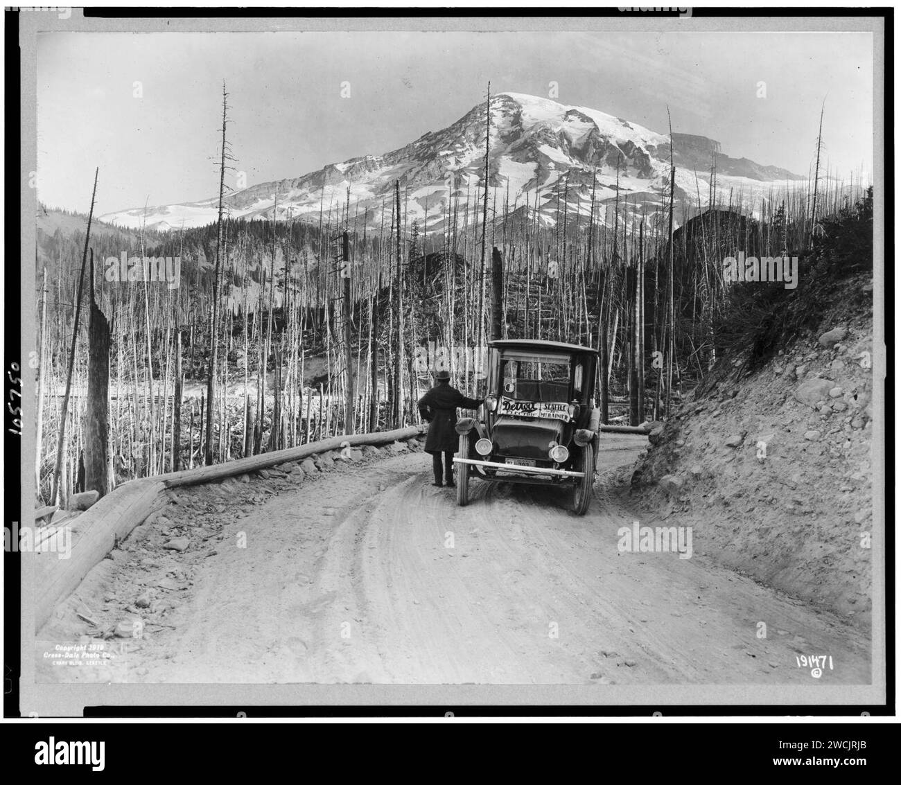 A Detroit automobile elettrica interrotta sulla strada da bruciate su terra, con coperte di neve montagna in background, Washington Foto Stock