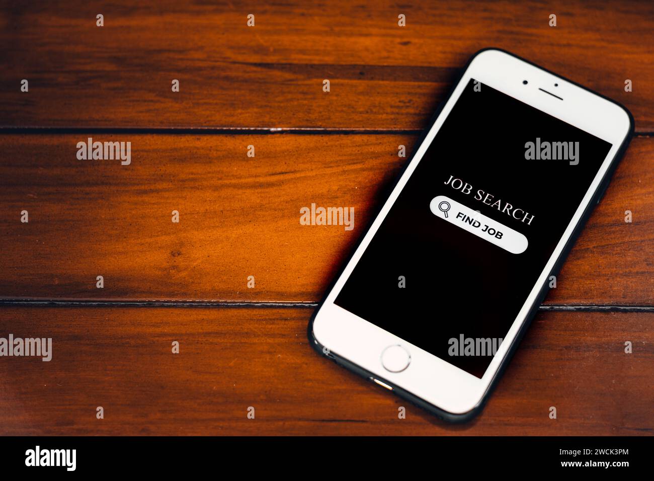 Concetto di ricerca di lavoro. Smartphone con app di ricerca del lavoro sullo schermo su sfondo in legno. Ricerca di opportunità di lavoro online. Foto Stock