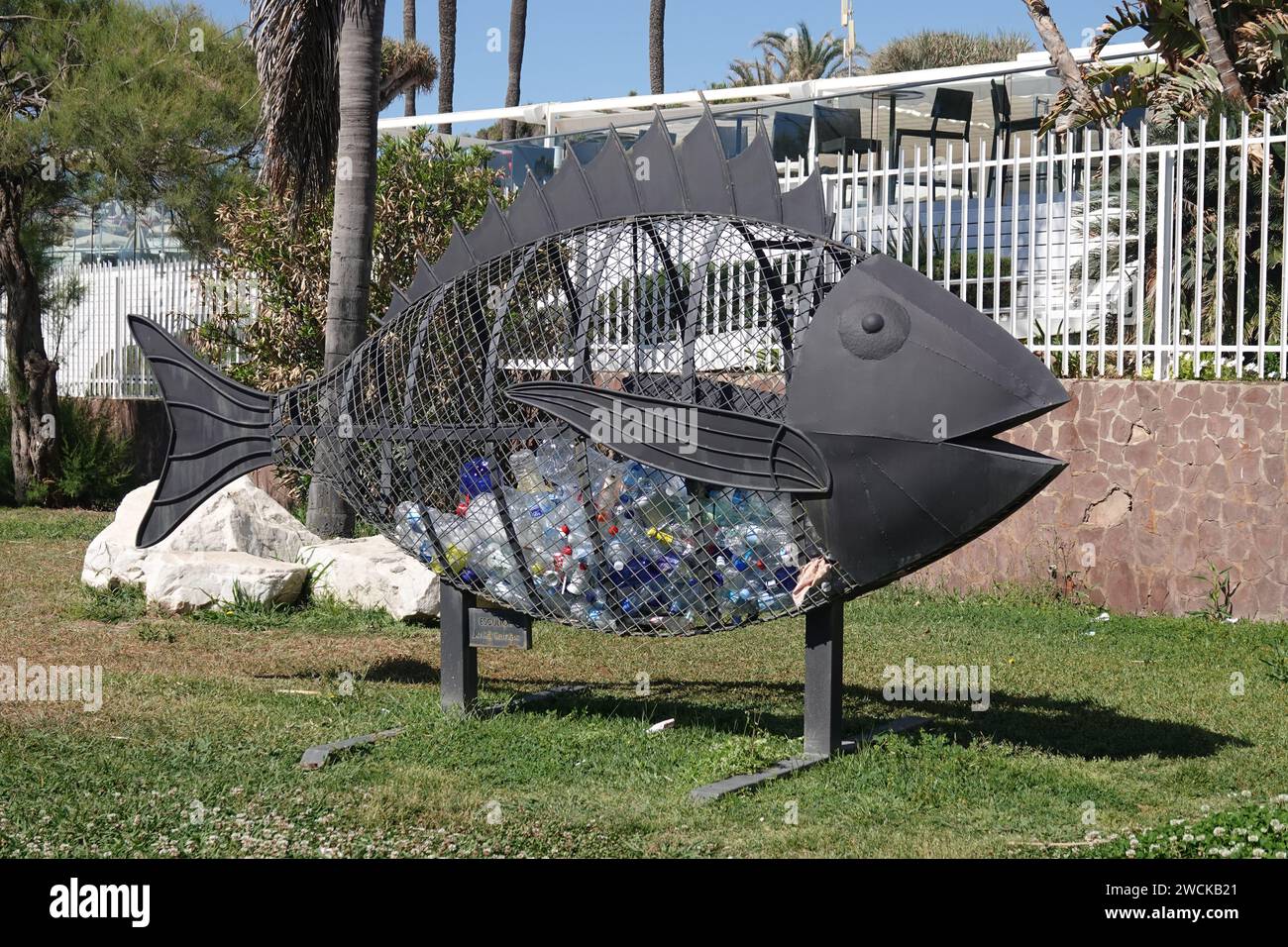 Un cestino dei rifiuti sotto forma di pesce situato sulla costa per ridurre l'inquinamento marino causato dai rifiuti di plastica Foto Stock