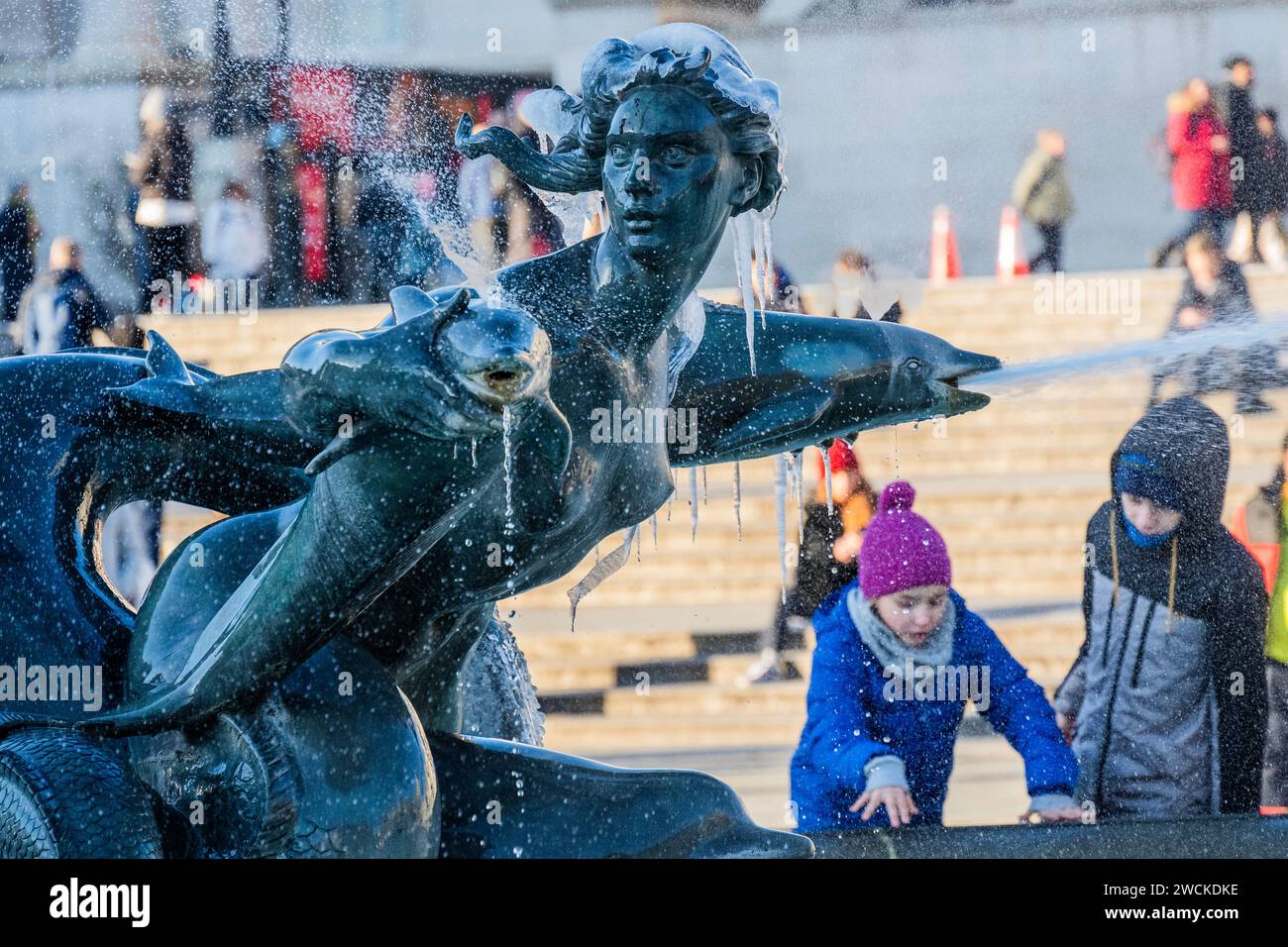 Londra, Regno Unito. 16 gennaio 2024. I passanti sono ben avvolti dal freddo invernale che congela l'acqua nelle fontane di Trafalgar Square. Crediti: Guy Bell/Alamy Live News Foto Stock